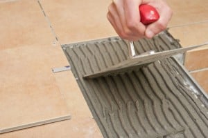 Spreading tile adhesive